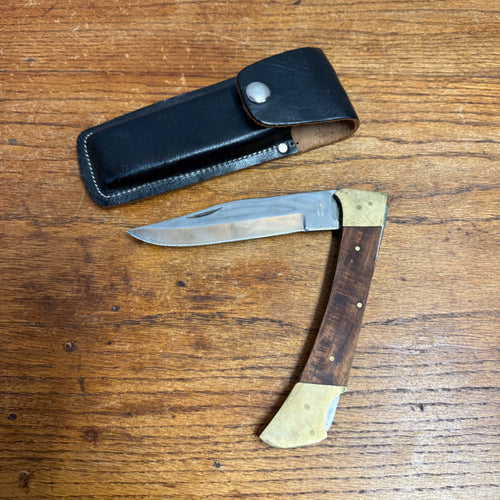 Vintage Stainless Steel Folding Knife With Brass-Accented Wooden Handle and Black Leather Sheath